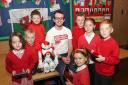 Using their iPads, pupils of Cefnllys Primary School in Llandrindod Wells make friends with Si-Nao the humanoid robot when he visited the school this week. Talking with the young people is Scott Morgan the digital lead with the group. The young people inc