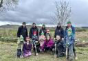 Local children with Urdd and Woodland Trust volunteers planting trees on 2024’s Urdd Eisteddfod site.