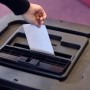 A person places a ballot paper into a ballot box. Picture: Stuart Walker