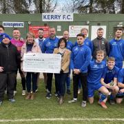 Kerry Football Club players and coaches present a cheque to Cancer Research UK ahead of their weekend clash.