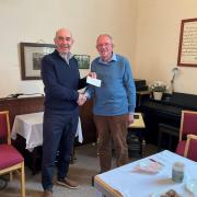 A cheque for £100 is presented to Reg Cawthorne, chairman of the Bracken Trust, by Pentref member Clive Barrett. 