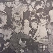 Maesyrhandir Primary School pupils pet a lamb on a school visit in 1980.