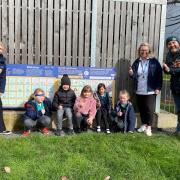 Claire Evans and Francesca Landers, from Powys Children’s Speech and Language Therapy Service, Ysgol Calon Y Dderwen pupils and Lee Davies, Operations Manager at Newtown and Llanllwchaiarn Town Council with the Makaton boards at Newtown play park.