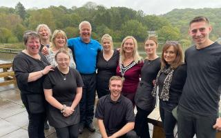 BBC weatherman Derek Brockway (back, 4th l) and Llandrindod's own Sue Charles (2nd r) pictured with staff at Lakeside Café during his spa town visit last year. (Image: Lakeside Boathouse)