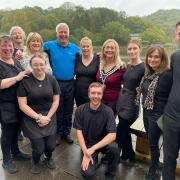 BBC weatherman Derek Brockway (back, 4th l) and Llandrindod's own Sue Charles (2nd r) pictured with staff at Lakeside Café during his spa town visit last year. (Image: Lakeside Boathouse)