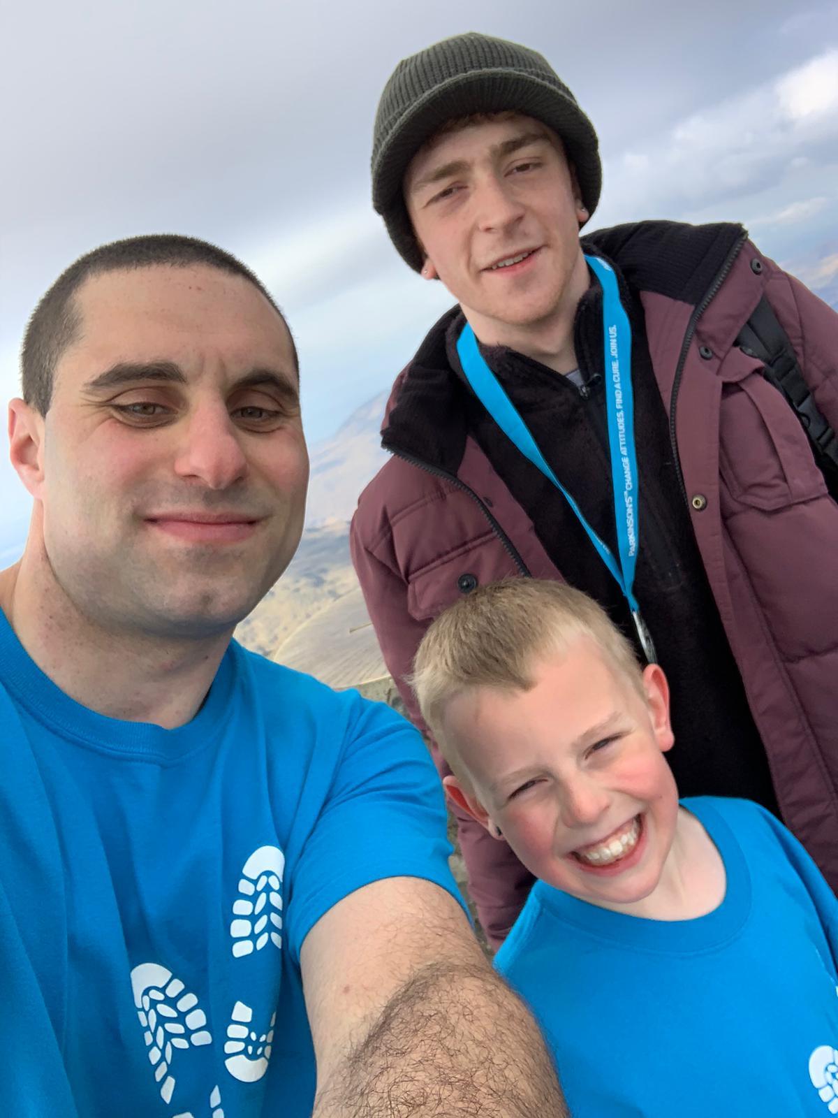 Joseph Mills, Henry Dyche and Daniel Trigg on the summit of Snowdon after their completing their fundraising challenge for Parkinsons UK.