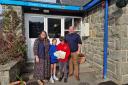 Sian Healey presents the 'Dan Y Bont' books to pupils at Llanelwedd Church in Wales Primary School, and headteacher Adam Shearman.