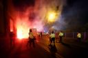 Police attempt to put out flares that have thrown towards them outside the stadium before the Uefa Europa Conference League Group E match at Villa Park, Birmingham (David Davies/PA).
