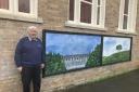 Artist Brian Earp with his murals outside Llanfyllin Library.