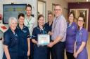 Oswald Ward Sister Sarah Kaye receiving her Health Hero Award from Chief Executive Mark Brandreth alongside her colleagues