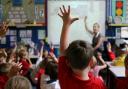File photo dated 06/07/11 of children at school raising their hands to answer a question. Photo credit: Dave Thompson/PA Wire.