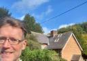 Llandrindod county councillor Jake Berrimanm, with Cross Cottage pictured in the background