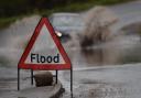 Flood warning sign on road.