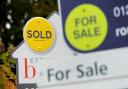 File photo of a sold and for sale signs. Pic: PA.