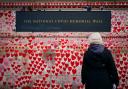 A person looks at National Covid Memorial Wall opposite the Palace of Westminster in central London, which bears hearts drawn by the relatives of people who have died of the virus. Picture date: Friday January 28, 2022.