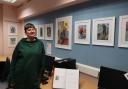 Artist Liz Neal with some of her portraits on display in Llanfyllin Library.