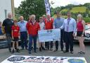 Wolverhampton and South Staffordshire Car Club chairman Guy Weaver presents a cheque for £500 to Caereinion High School headteacher Huw Lloyd Jones, chairman of governors Gareth Jones watched by Trailhead Fine Foods executive chairman Arwyn Watkins,