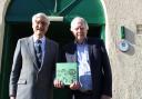 Eisteddfod chairman Hywel Davies presents Charcroft Electronics’ Paul Newman with the first copy of the Llanwrtyd Eisteddfod book.