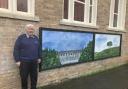 Artist Brian Earp with his murals outside Llanfyllin Library.