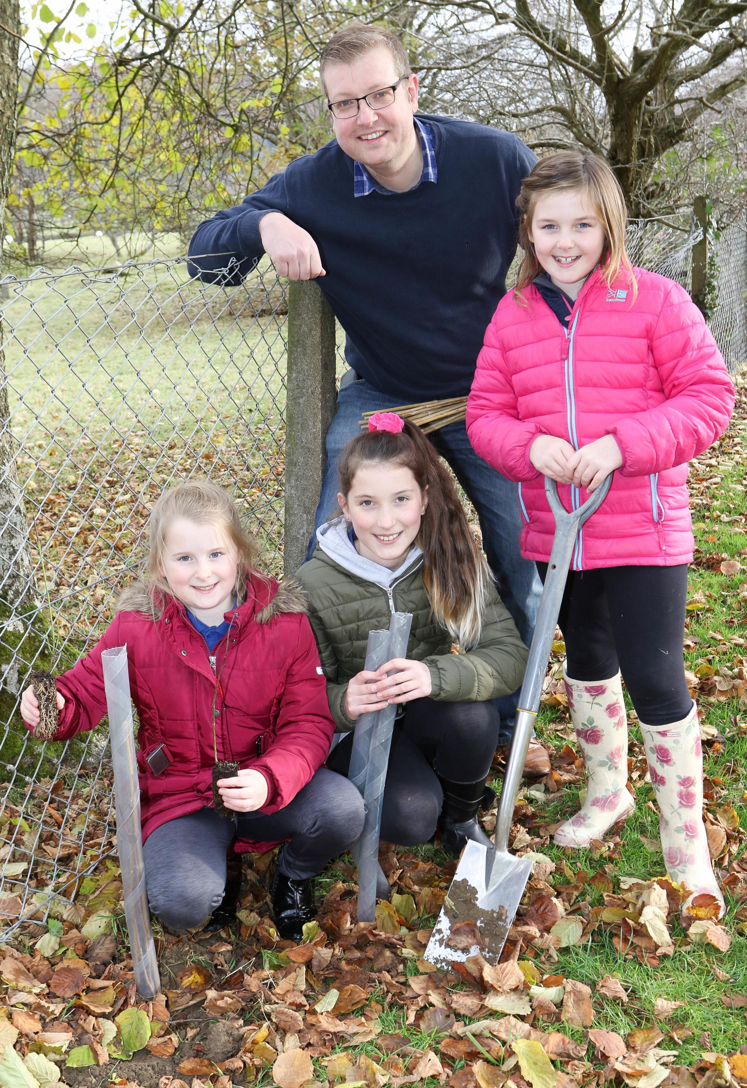 Llandinam Primary School..The Woodland Trust have given the school 20 trees to plant around the edge of the school field..Pictured is County Cllr Karl Lewis (Chairman of the Governors) with left to right, Rhian Morgan (9) Sophie Pugh (10) and Ruby Jones