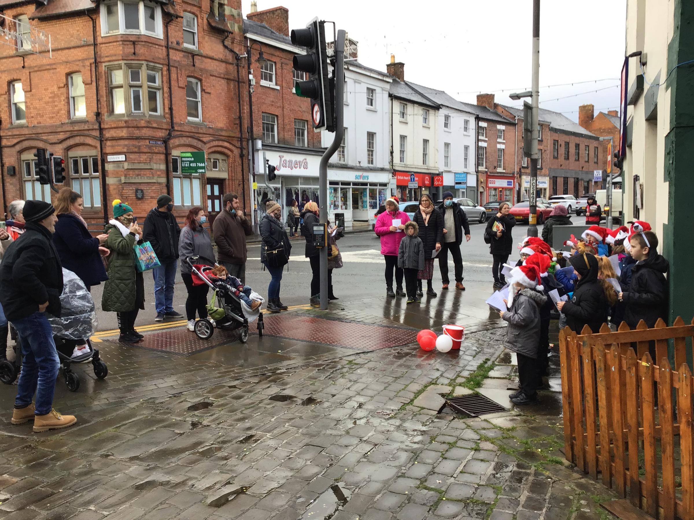 Christmas shoppers enjoy listening to carols sung by pupils from Welshpool Church in Wales Primary School.