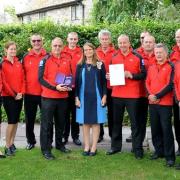 Members of Brecon Mountain Rescue Team, pictured with their award and with Lord Lieutenant of Powys Tia Jones