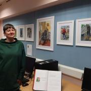 Artist Liz Neal with some of her portraits on display in Llanfyllin Library.