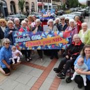 Knit and Natter Newtown group with their postbox topper celebrating the NHS' 75th anniversary.