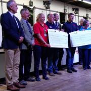 Lloyd (centre) presents cheques of £10,080 to both the Wales Air Ambulance and Parkinson's UK Cymru