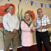 David Rawsthorne, pictured with the mayor of Llandrindod Marcia Morgan and club chairman David Vaughan. The town council has donated £100 to the fix the roof campaign.