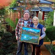 Davy presents a painting he made especially for Tranquility Haven owner Val Brown