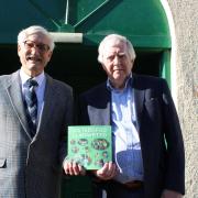 Eisteddfod chairman Hywel Davies presents Charcroft Electronics’ Paul Newman with the first copy of the Llanwrtyd Eisteddfod book.