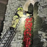 A firefighter from Llanfair Fire Station helps to set up the display at St Mary's Church.