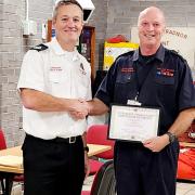 Steve Amor (r) receiving his long-service award from assistant chief fire officer Craig Flannery.