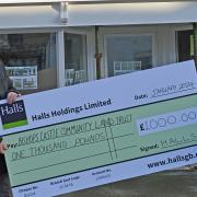 David Bryan Jones, manager of Halls’ Bishops Castle office, presents a cheque for £1,000 to Kate Evans, Bishops Castle & District Community Land Trust chair, outside the building that is being renovated and converted into two flats and a pop up shop.