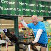 Philip Jones cycling at the entrance of Welshpool Morrisons.