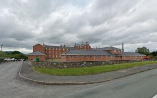 The former workhouse, Grade II listed Plas Maldwyn in Caersws - the site earmarked for 22 homes would be near where the parked cars. From Google Streetview.
