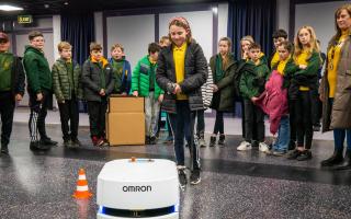 A pupil from Ysgol Dafydd Llwyd test out the Omron mobile robot from Reeco at Newtown College.